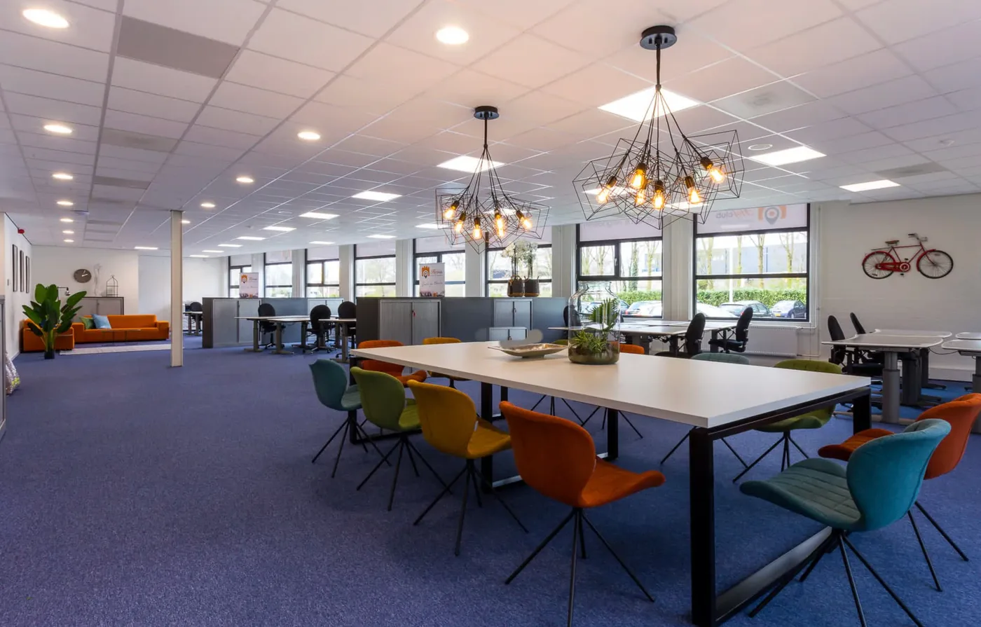 Het werkcafé van Hofclub Utrecht met lange tafels en hanglampen